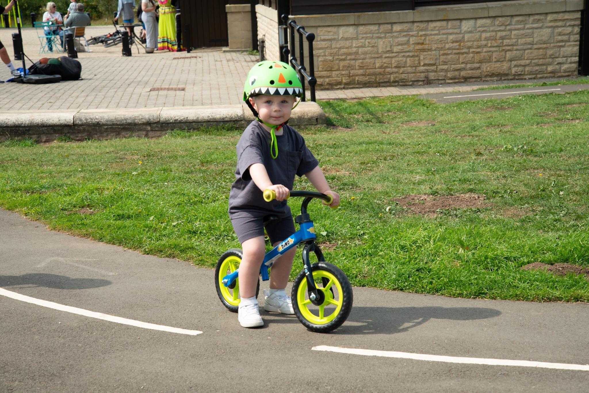 Young child wearing a green helmet cycling at Summerhill