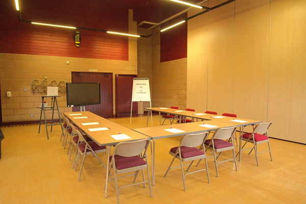 Meeting room with chairs laid out in a U shape with flip chart and TV to the front