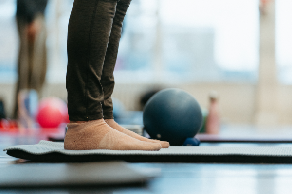 The photograph shows a close up shot of feet on a yoga mat